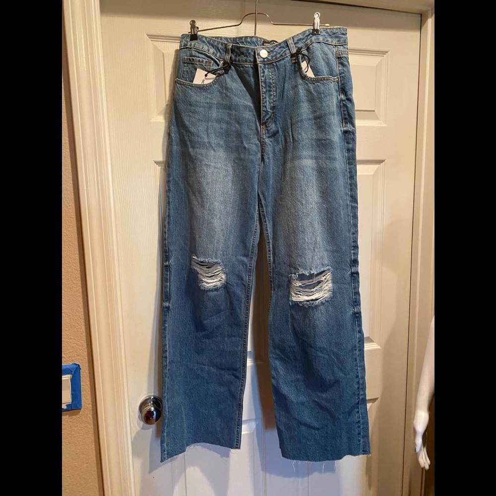 Wide leg jeans with distressed knees and cut off hem.